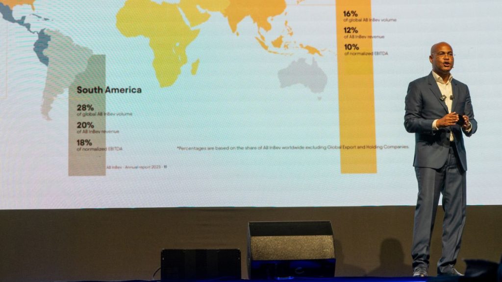Marco Jensen presentando estadísticas globales de negocio en un evento corporativo.